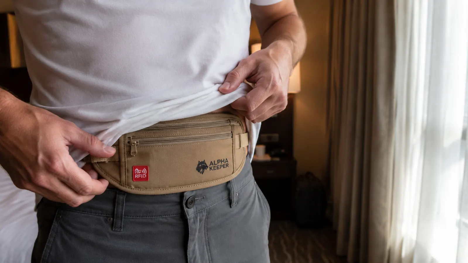 Hand tucking a flat travel money belt under a t-shirt before heading out